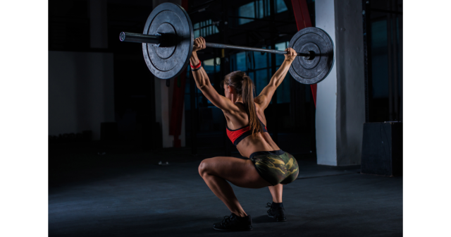 young woman performing a snatch weightlifting move