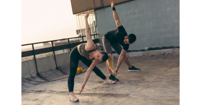 man and woman dynamically hamstring stretching