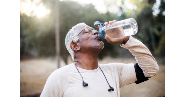 older man drinking water from a sports bottle