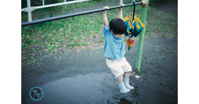 Boy hanging off a bar