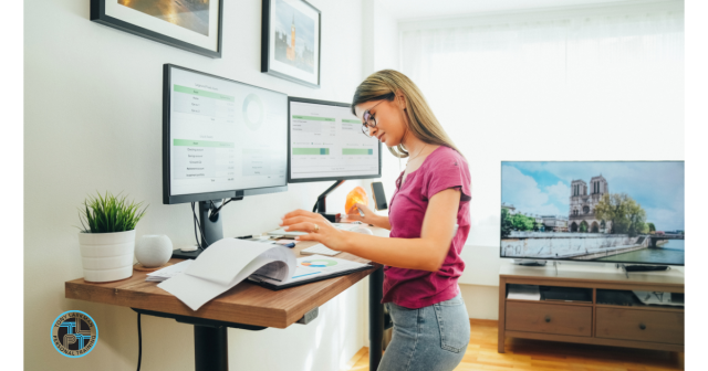 woman at a standing desk working on a computer