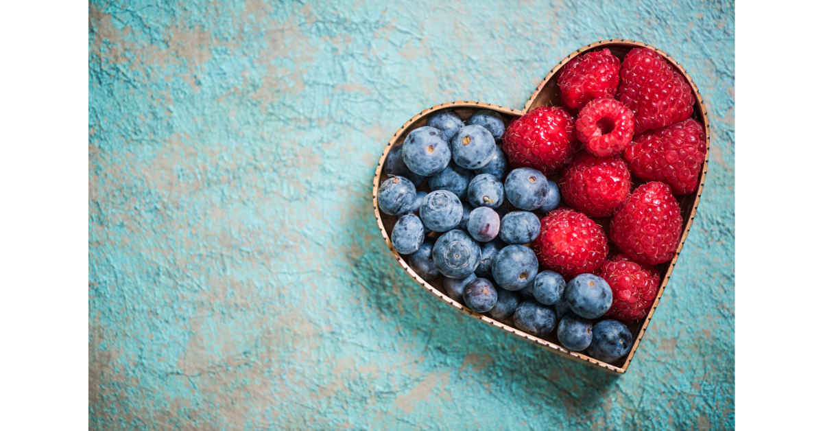 Heart-shaped bowl filled with blueberries and strawberries symbolising healthy nutrition for heart health and longevity