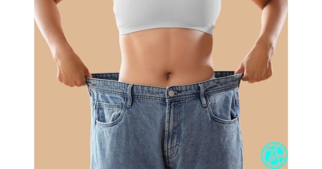 Person showing weight loss progress by holding oversized jeans after fat loss