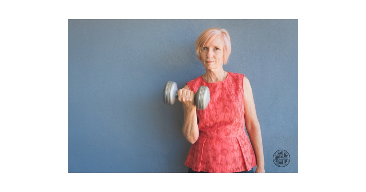 Woman over 50 performing a dumbbell exercise to build muscle and maintain strength with age.