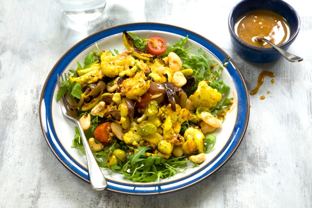 turmeric roasted cauliflower, sprout and butterbean salad on a plate and sauce