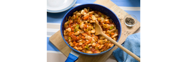 smokey butter beans in bowl with wooden spoon