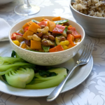 bowl of Thai vegetable curry with kiwi fruit on plate and rice in a bowl
