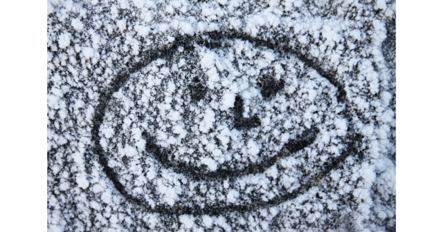 smiling face drawn in snow on tarmac path