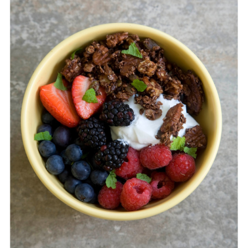 chocolate granola and berries in cereal bowl