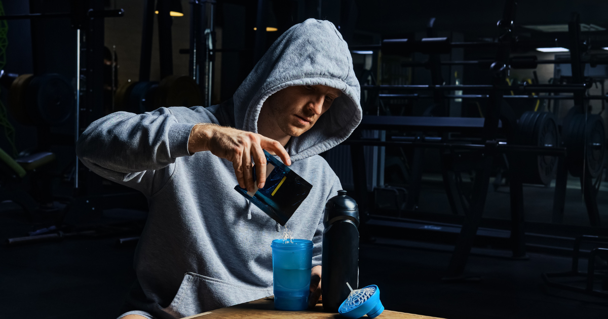 man in hoodie mixing pre-workout powder