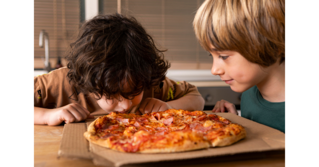 2 boys eating pizza