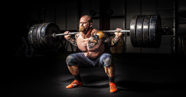 man squatting heavy weights